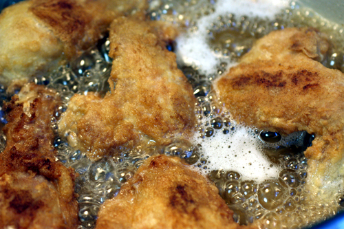 Chicken frying in hot bubbling oil